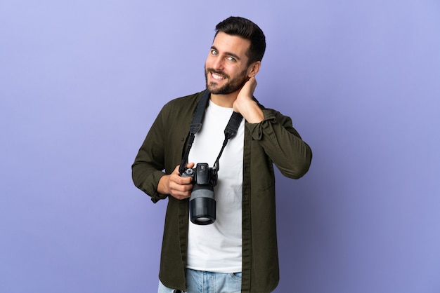 Photographer man over isolated purple laughing