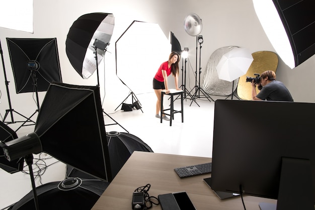 Photographer and model working in a studio