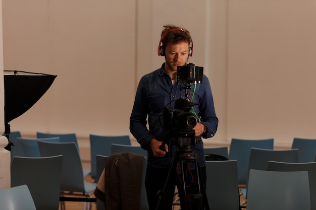 Photo photographer operating digital camera in studio