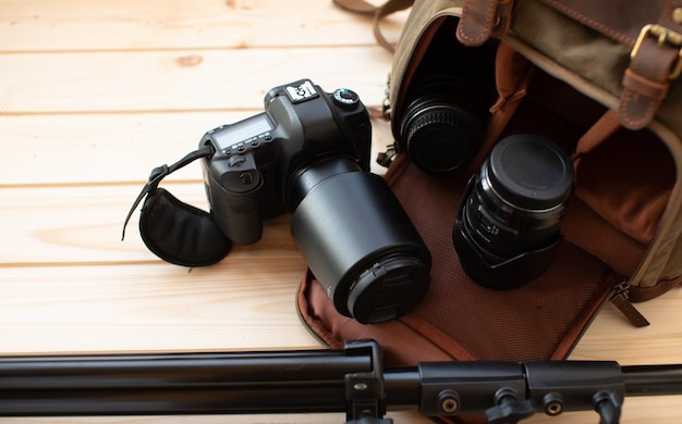 Фото Фотограф кладет камеру и объективы в рюкзак сумка для техники для фотосъемки