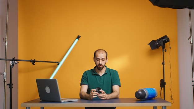 Foto fotografo che registra la revisione dell'obiettivo tecnologico per gli abbonati ai vlog in studio. tecnologia dell'obiettivo della fotocamera registrazione digitale creatore di contenuti influencer social media, studio professionale per podcast, vlogging e