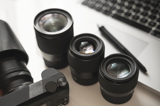 현대적인 장비를 갖춘 사진 작가의 작업장. 미러리스 카메라, 노트북 및 단렌즈.