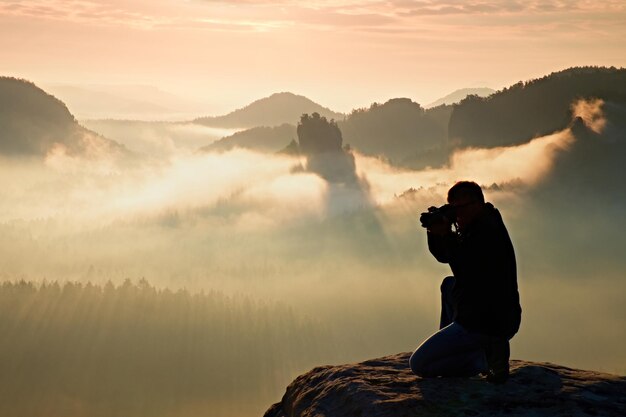 写真 雲の上の写真家のシルエット 霧の山の海