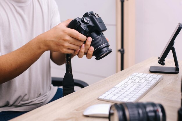 写真 写真家が座って ⁇ プロのカメラのボタンを押して ⁇ 撮影をレビューしたり ⁇ カメラを設定したりします ⁇