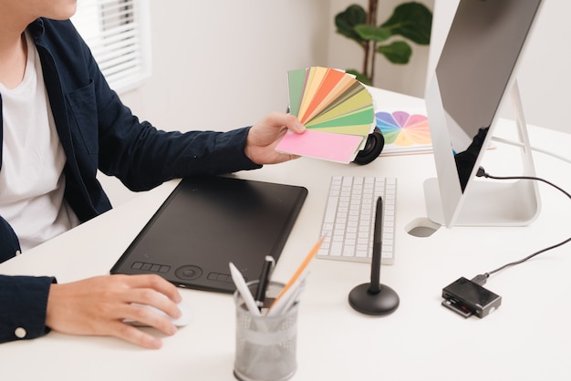 Photographer sitting at desk retouching new photos in his studio