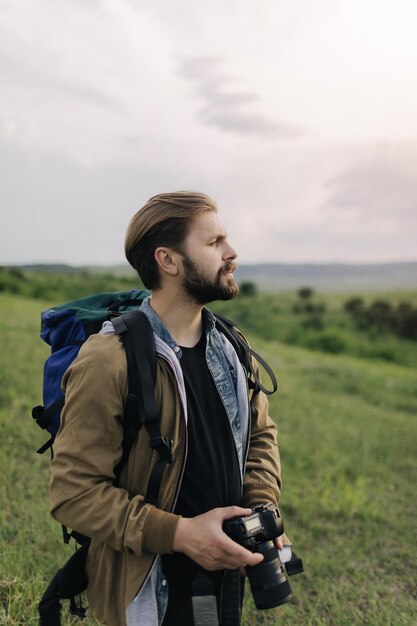 Photographer standing at field and holding digital camera