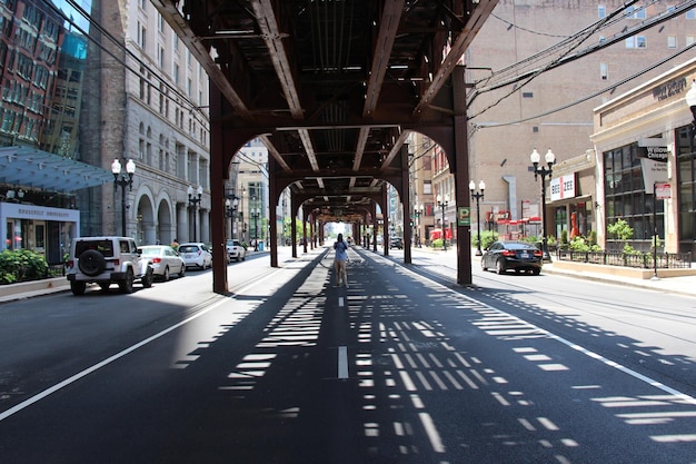 Photographer standing in the middle of the street with l train overhead