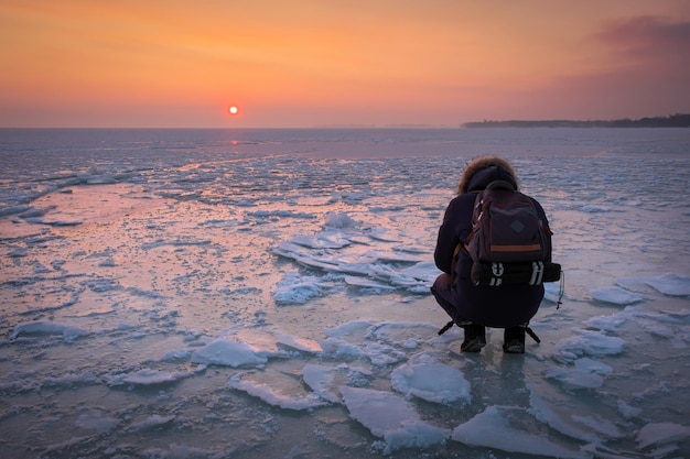 Foto il fotografo scatta foto sul ghiaccio durante il tramonto