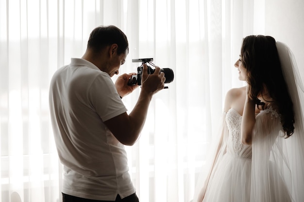 Photo a photographer takes a photo of a bride in a wedding dress.