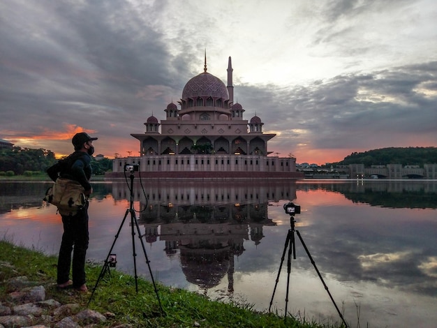 A photographer takes a photo of a mosque in malaysia.