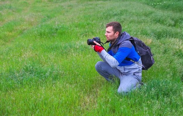 Il fotografo scatta foto sull'erba in primavera