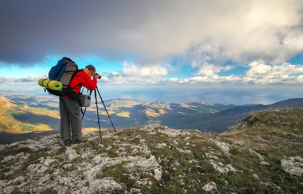 Photographer takes pictures on top of the mountain in autumn