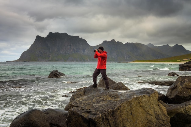 Photographer takes pictures at uttakleiv beach on lofoten island