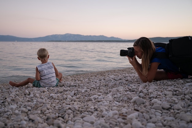 Photographer taking photos of a boy playing on the beach