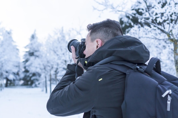 寒い冬の日に雪景色で写真を撮る写真家