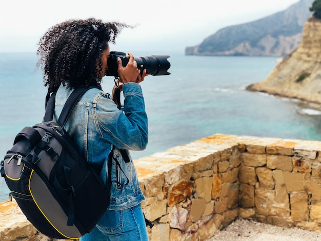 Fotografo che prende un'immagine di una costa dell'oceano