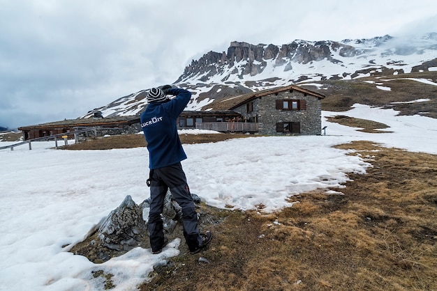 Fotografo che scatta foto di montagne delle alpi vicino a un rifugio