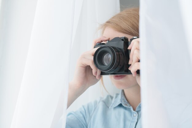 Foto fotografo che scatta foto attraverso la tenda bianca