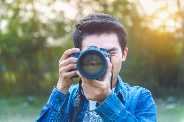 Фото Фотограф фотографирует с помощью цифровой камеры. винтажный тон.