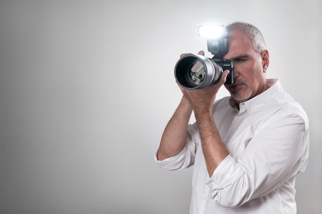 Photographer using a professional camera with the flash on