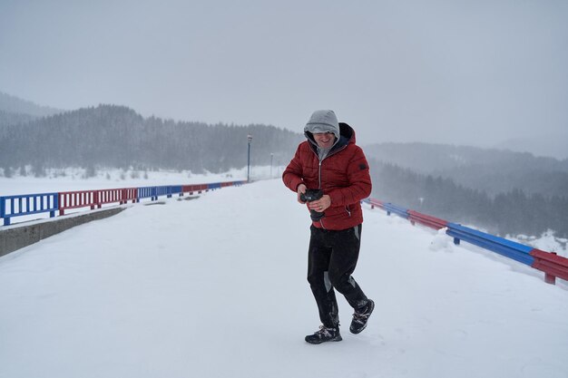 Photographer with camera in the blizzard in the mountains