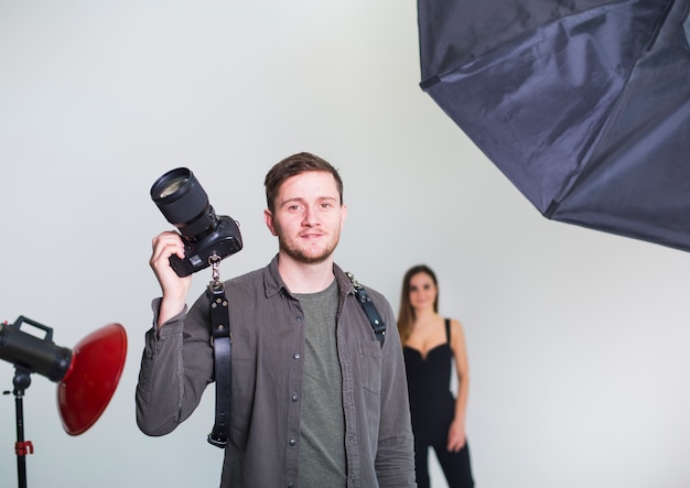 Photographer with camera standing in studio