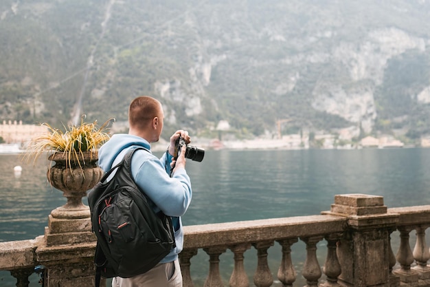 Photographer with a camera taking a picture of the snow mountains against blue sky in the Alps Wanderlust concept