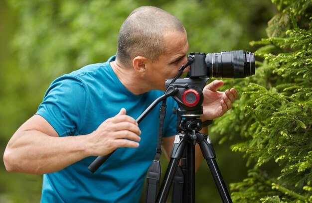 Photographer with camera on tripod shooting a macro scene