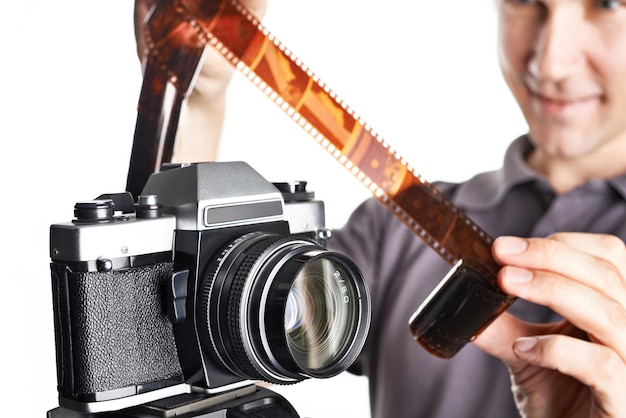 Photographer with color negative near SLR camera isolated