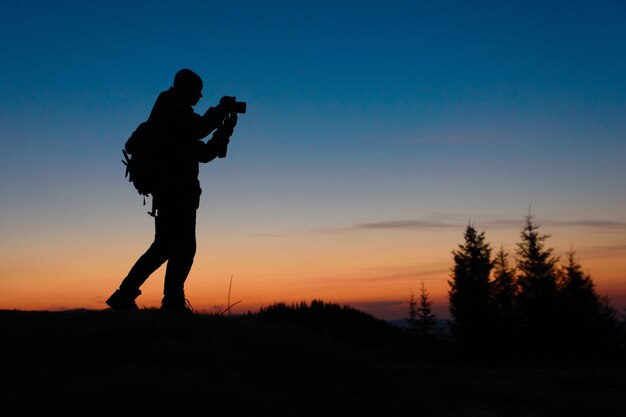 Photographer working with camera at sunset outdoors