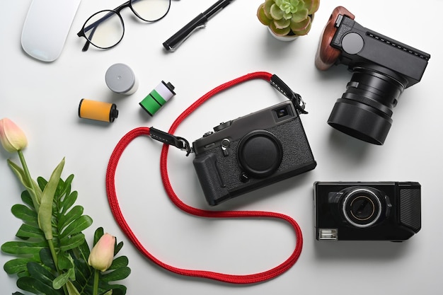 Photographer workspace with digital camera and accessories on white table