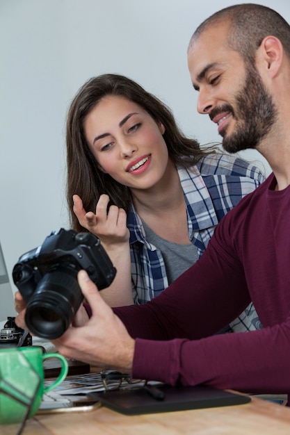 Fotografi che esaminano le foto catturate con la sua fotocamera digitale