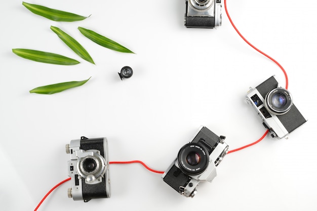 写真 写真機器ヴィンテージ、白い背景の上の緑の葉と作業スペースの概念。