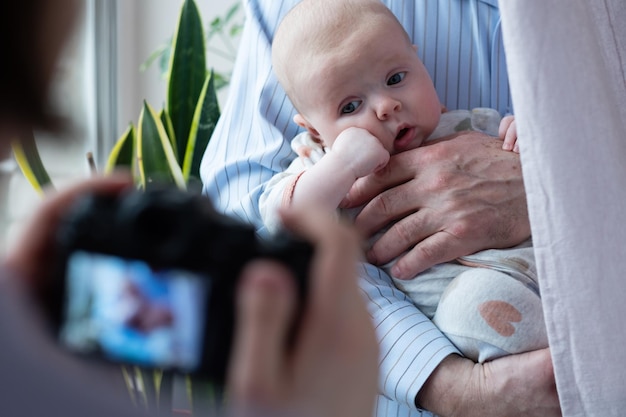 Photographing baby girl or shooting video on digital camera funny family photo session