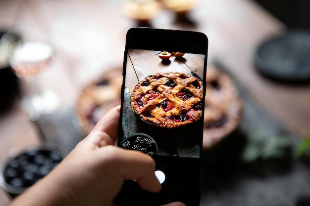 Foto fotografare una torta di frutta a reticolo con uno smartphone