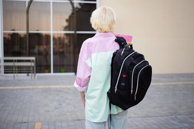 写真 フォルダと大きなバックパックを持った学生の女の子の後ろからの写真