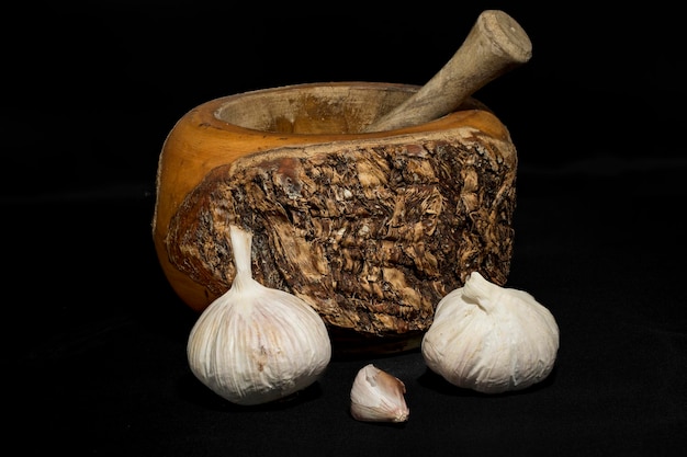 Photography of garlic with mortar on black background