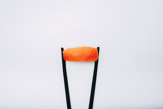 Foto fotografia di nigiri di salmone giapponese con bacchette nere