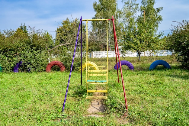 子供用の金属ブランコをテーマにした空の遊び場での写真撮影