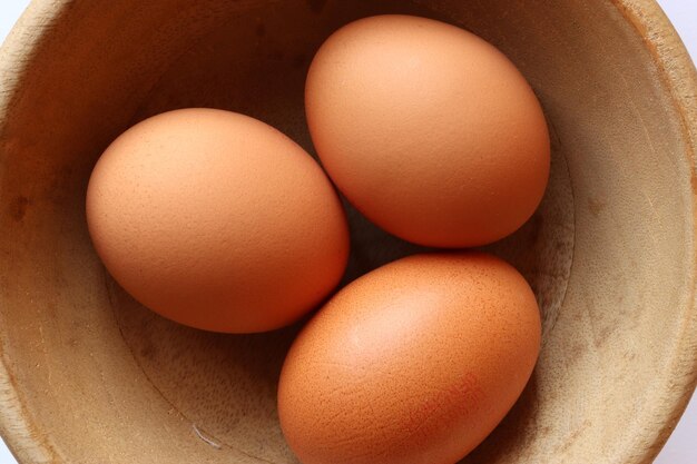 Photography of three eggs in a wooden bowl for food background