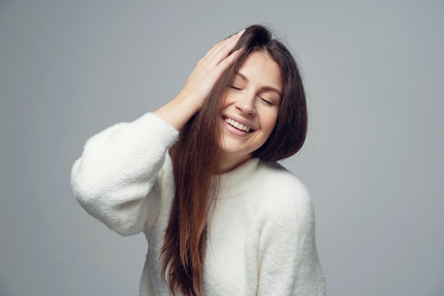 For photos of the hand touching the hair around the face portrait of smiling young brunette