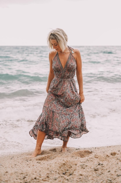 Photoshoot of a pregnant woman walking on the beach