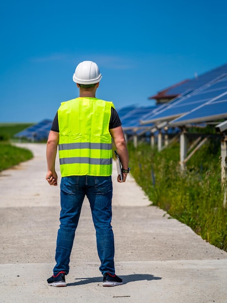 Photovoltaic energy construction site engineer at work view
from the back