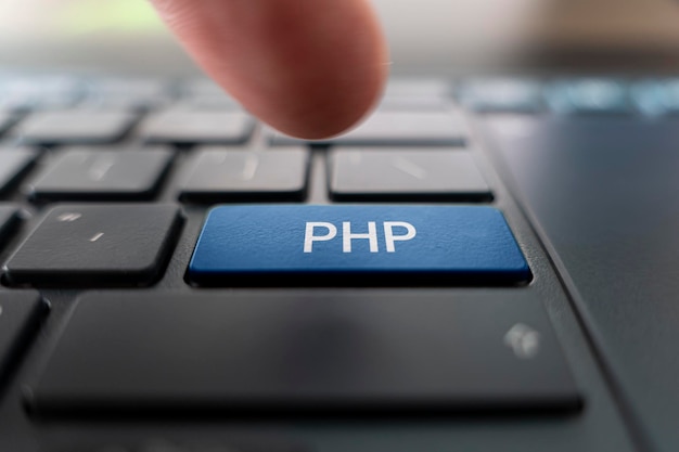 Photo php logo on pc keyboard writing code php programming creating web projects in hypertext preprocessor language website development finger presses the button