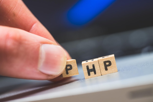 PHP programmeren webtaal Houten kubussen met letters PHP liggend op een laptop concept