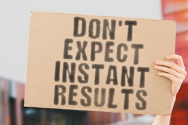 The phrase Don't expect instant results on a banner in men's hands with blurred background Productivity Process Personal Plan Planning Successful Strategy Urgent Moment Success Action