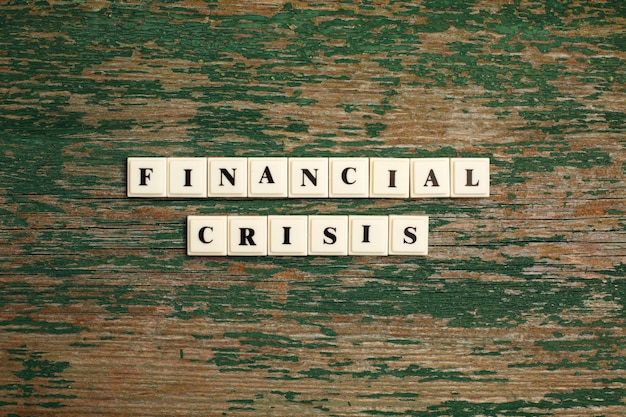 Phrase Financial Crisis made of plastic block letters on old wooden backgraund