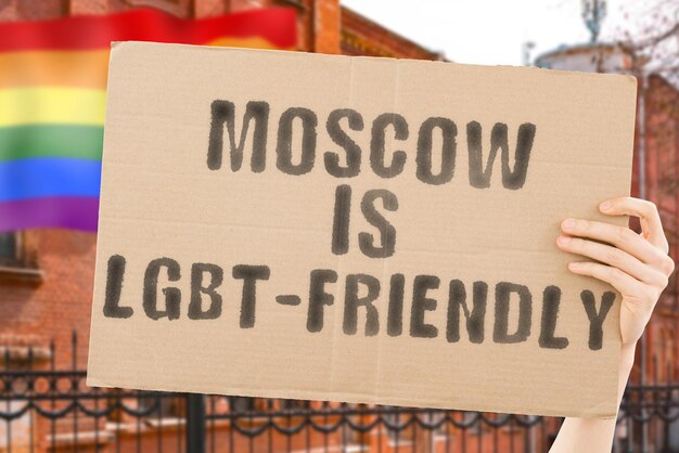 The phrase  Moscow is LGBTFriendly  on a banner in mens hand with blurred LGBT flag