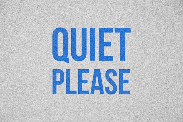 Phrase Quiet Please on white textured wall