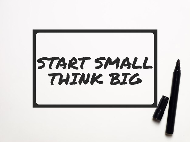 Phrase start small think big written on white background. Inspirational quote.